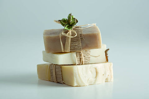 Three bars of soap stacked. Wrapped delicately in string with a flower on the top