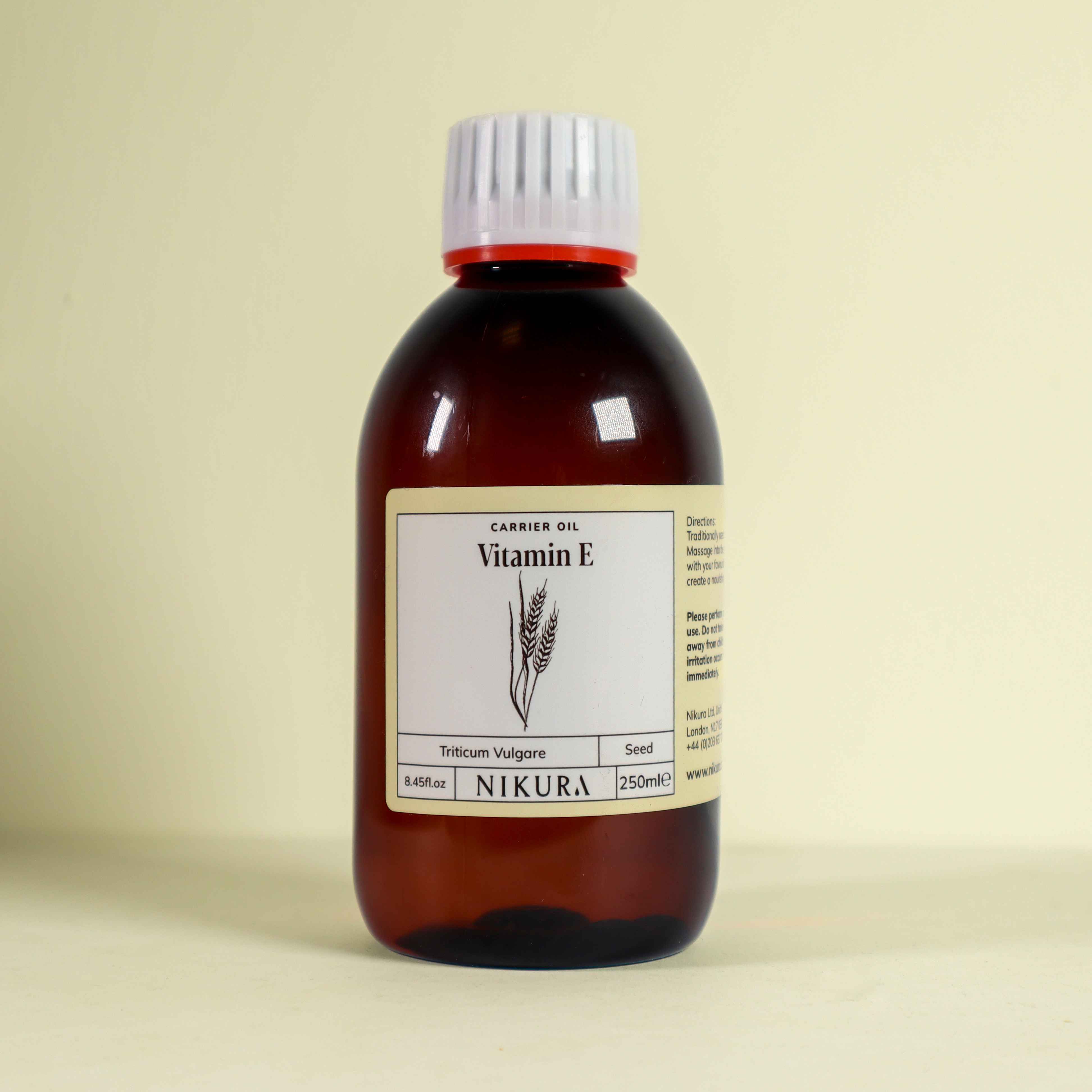 Nikura 250ml Vitamin E Oil on a yellow background.