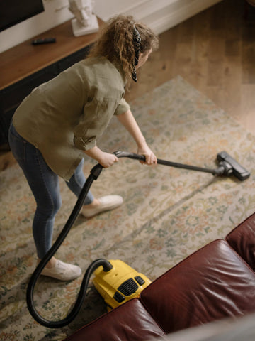 Woman hoovering her living room