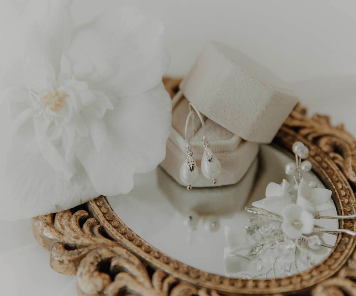 Brautschmuck im Flatlay zeigt Ohrringe mit Muschelkernperlen und Haarnadeln mit Perlen von Mia&Martzha