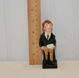 There is a ruler standing to the left of the figurine  and shows that the figurine is almost 4 inches tall.