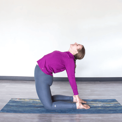 Une femme réalisant la posture du chameau