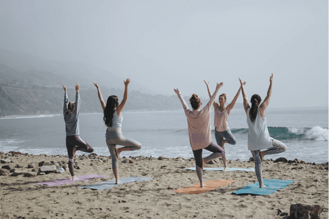 Des personnes pratiquant du yoga sur la plage