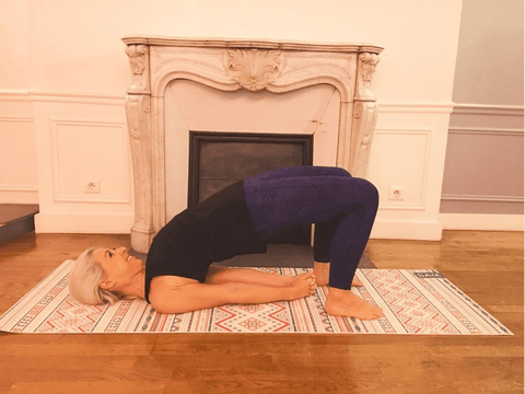 Une femme qui réalise la posture du demi-pont