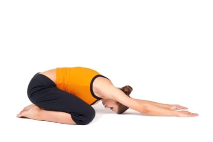 une femme faisant asana crianca - pose des enfants