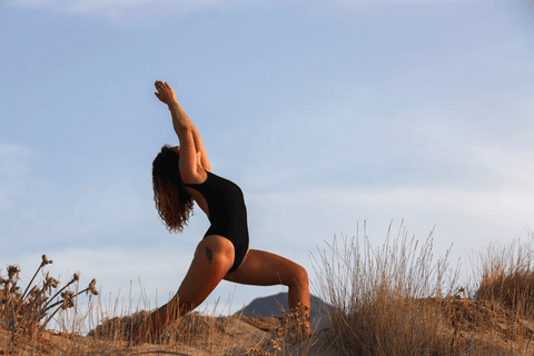 Une femme réalisant le Virabhadrasana III sur une plage