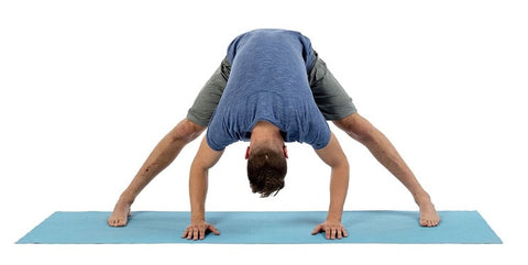 un homme faisant une pose de yoga sur un tapis