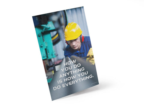 A safety poster showing a man in a yellow hard hat, red earmuffs and safety glasses, working in a factory with the slogan "HOw you do anything is how you do everything" below him.