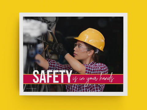 A framed hand safety poster showing a woman in a hard hat working on a machine.