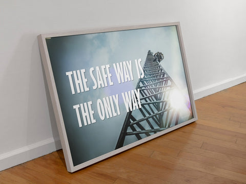 A framed fall safety poster leaning against a wall.
