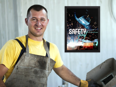 A welder in front of a welding safety poster.