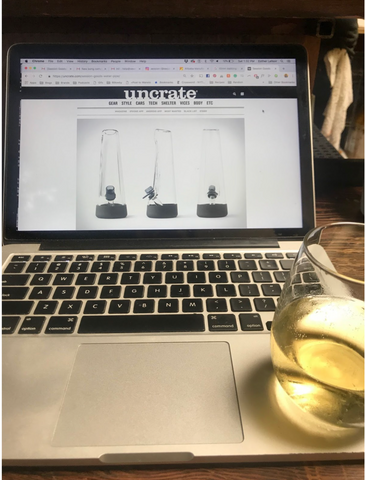 An open computer with a wine glass in frame celebrating the Uncrate write up.