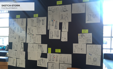 A black presentation board filled with sketches of various shapes and concepts for potential bong designs.