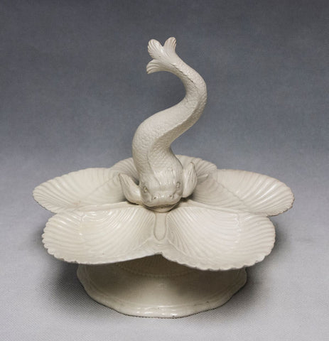 An English Creamware sweet meat dish with a dolphin handle surrounded by five shells, c1780-90