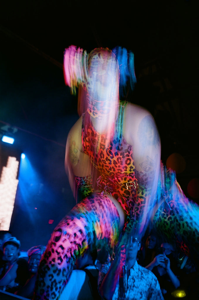 motion-blur shot bushwig festival-goer on stage in costume.