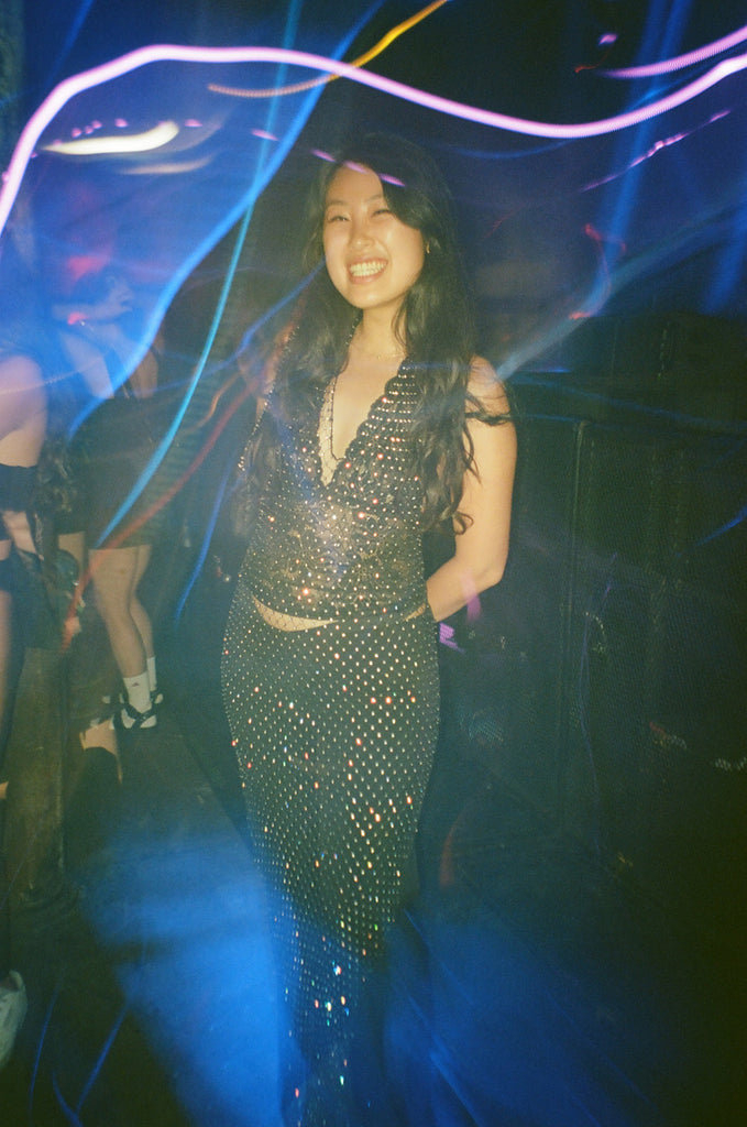 attendee in sparkling dress amidst lights.