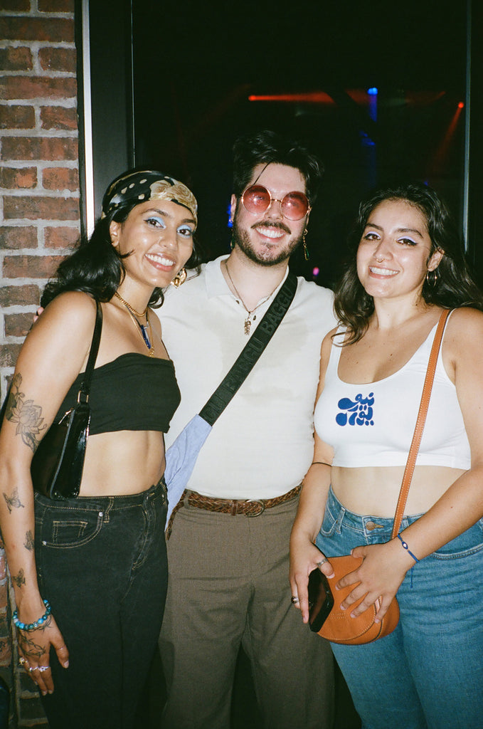 group of three friends posing outside.