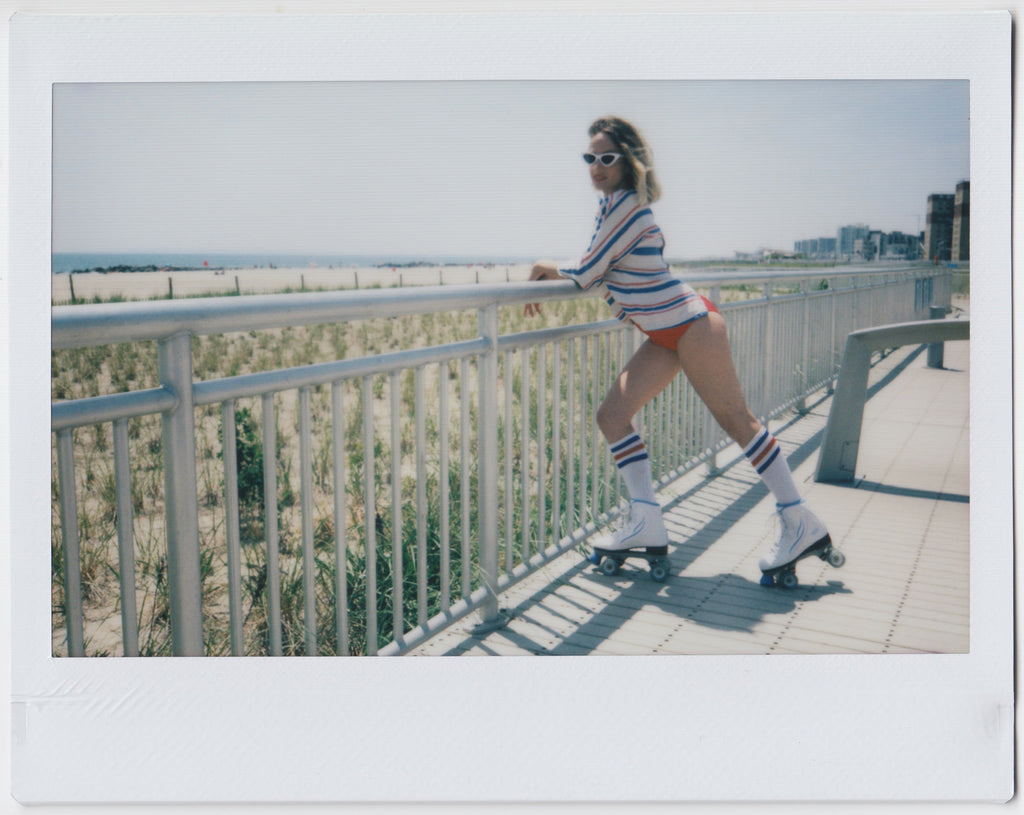 model in roller skates in red white and blue on the boardwalk.