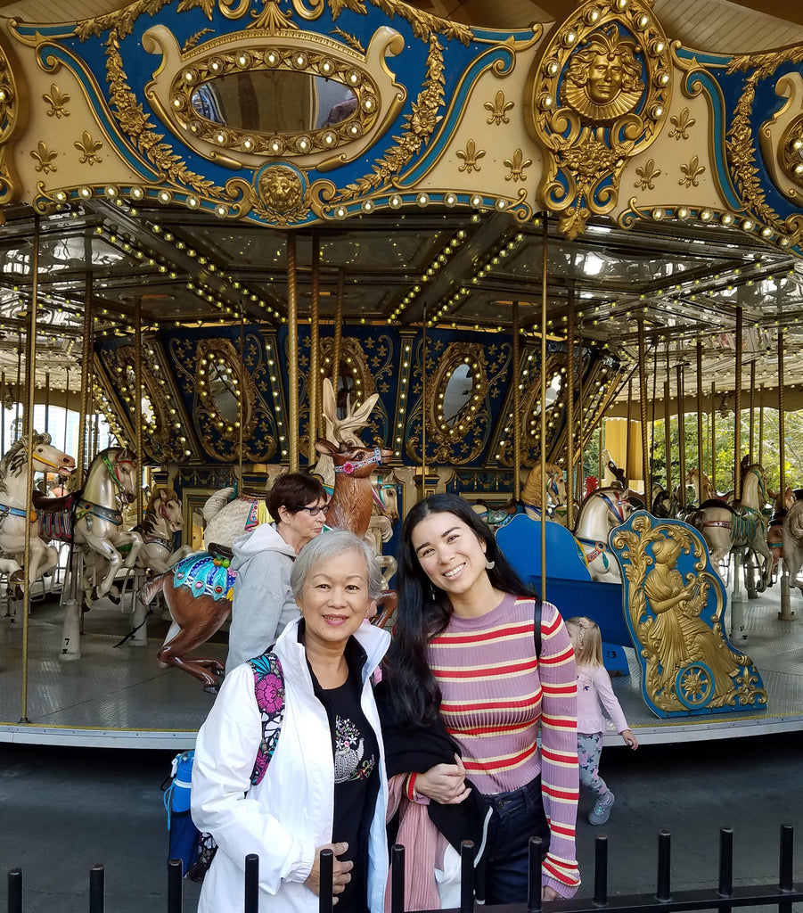duo posing in front of carrousel.