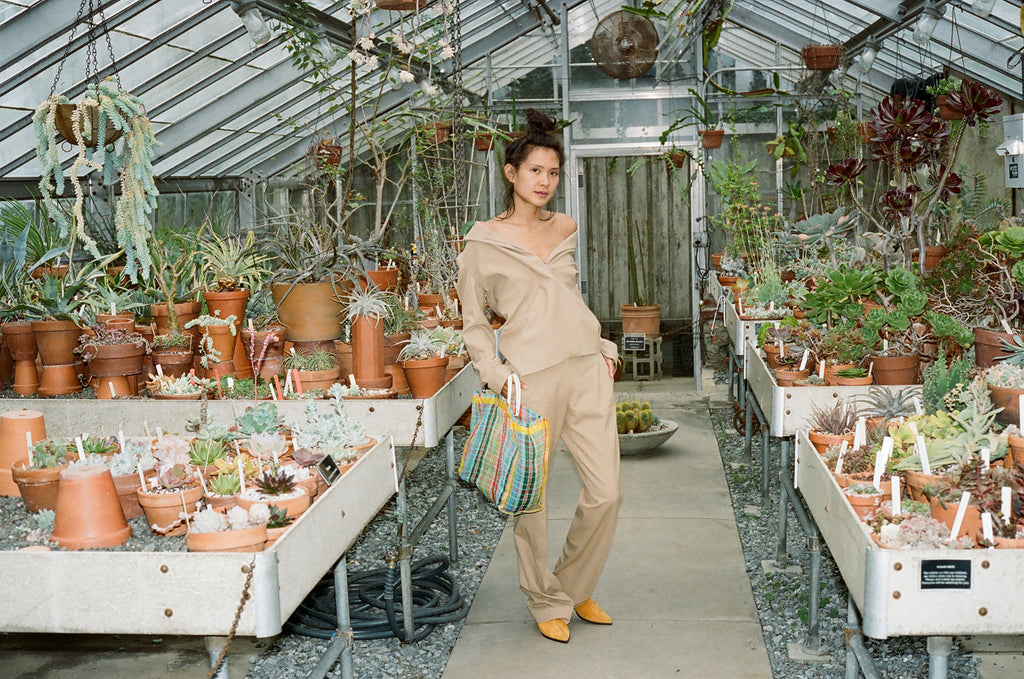 full body of model in suit in succulent greenhouse.