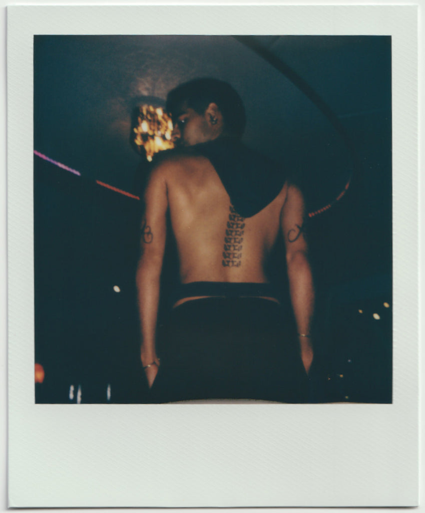 employee posing with tattoos on back - polaroid style.