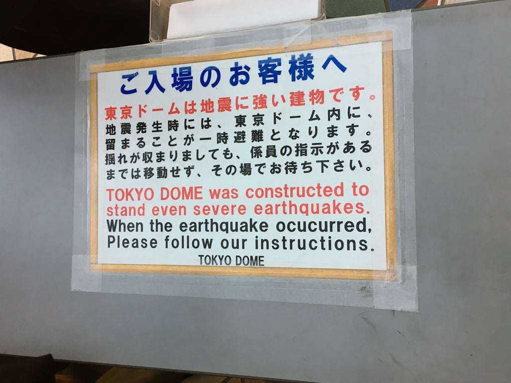 a sign that says 'tokyo dome was constructed to stand even severe earthquakes'.