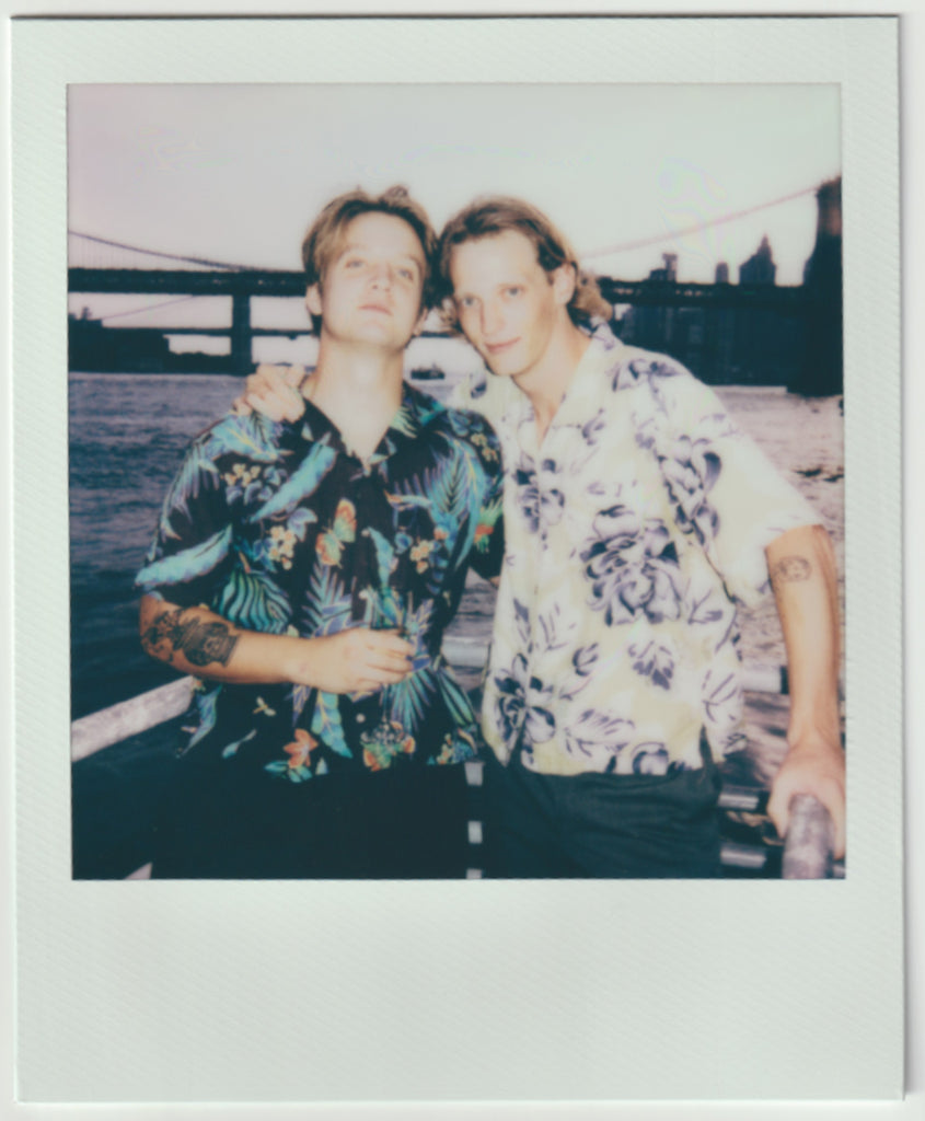 people side by side in floral shirts, posing for the camera.
