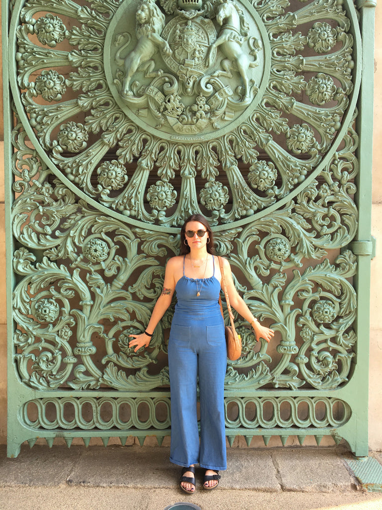 a person posing in front of an ornate gate.