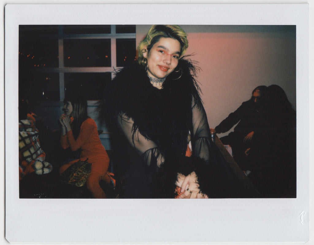 person posing with people hanging out in the background - polaroid style. 