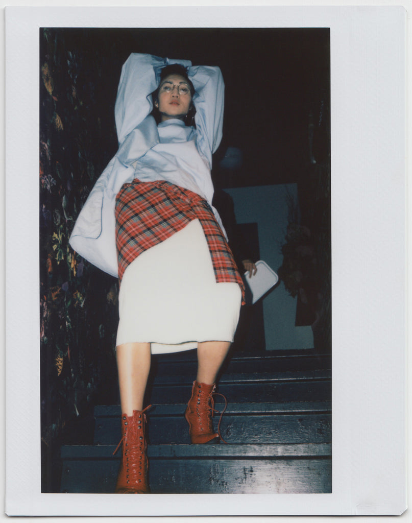 person posing on stairs, arms overhead, in full body shot - polaroid style.  