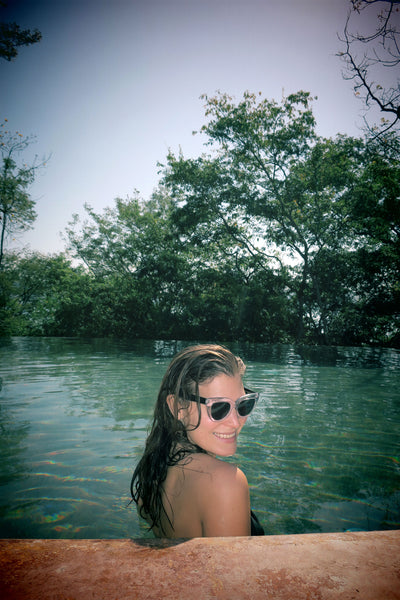 dana smiling wearing sunglasses in the pool. 