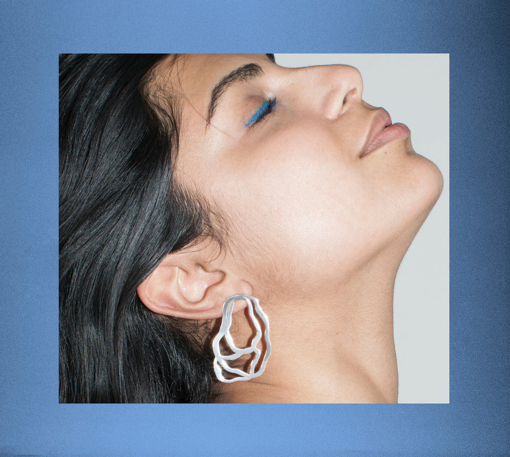 model in striking eye liner modeling earring.