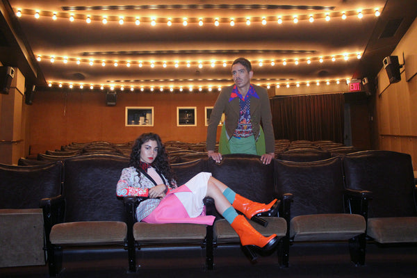 models posing on rows of theatre seats.