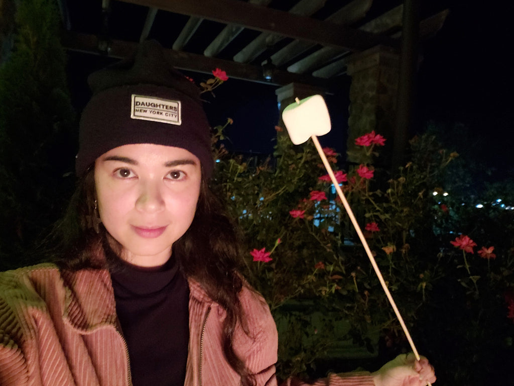 person looking at camera holding marshmallow.