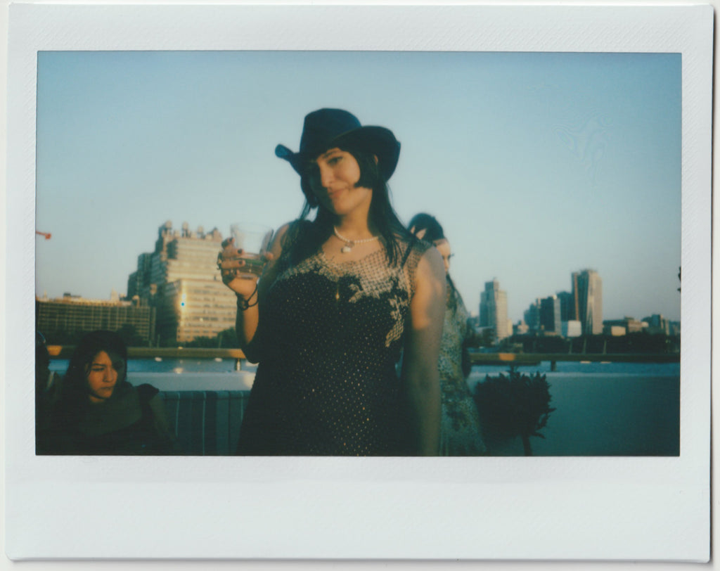 employee posing to the camera with cowboy hat - polaroid style.