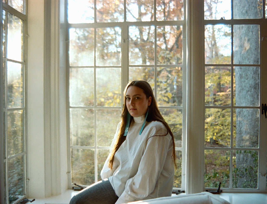 delcey sitting in front of a window.