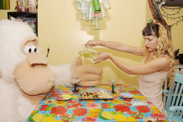 table scene features eartheater pouring stuffed monkey a cocktail.