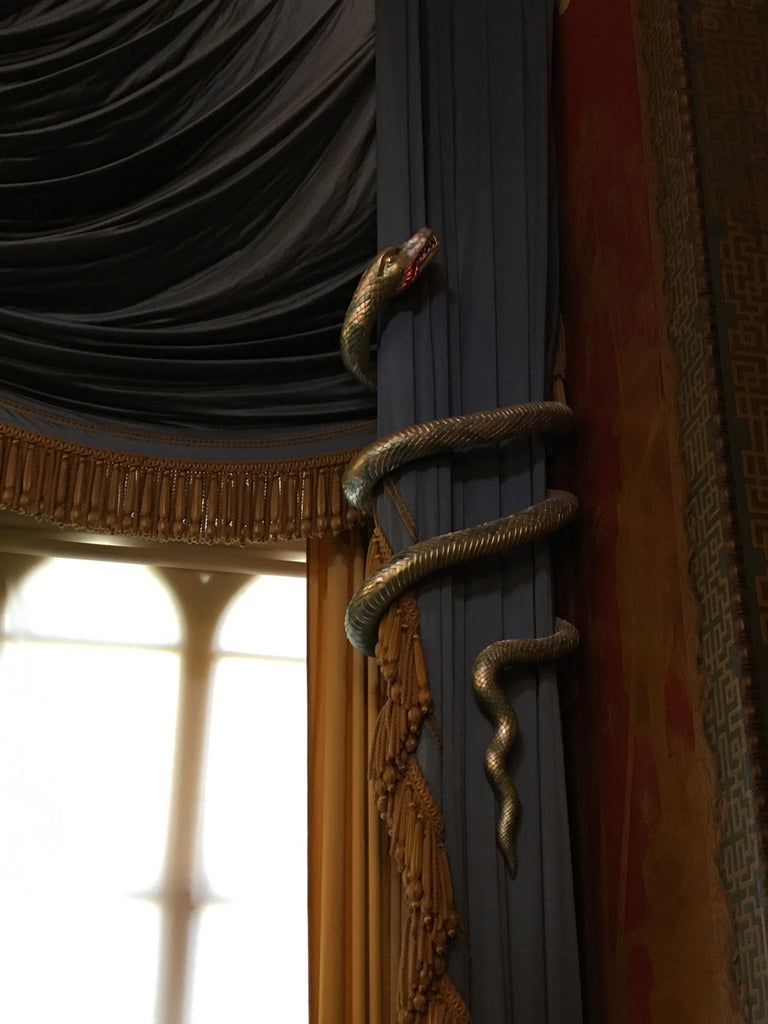 a snake hanging from a curtain in a room.