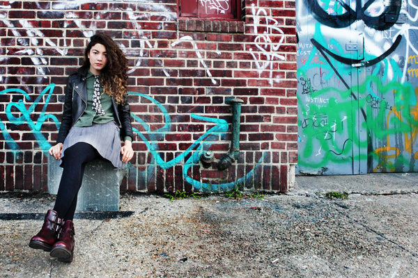 model sitting in front of brick wall 