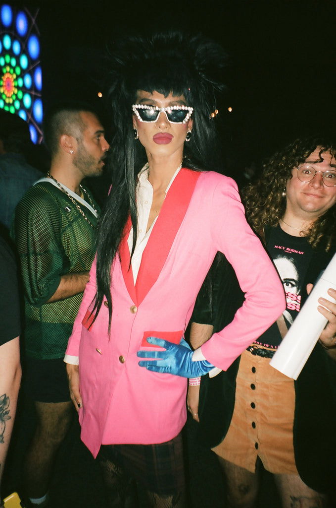 bushwig festival-goer in costume with two people in background, one wearing 'macy rodman' t-shirt.