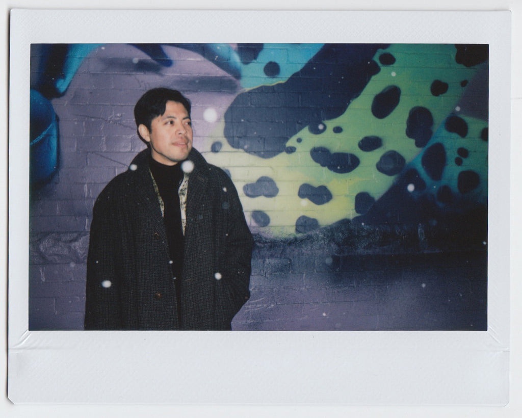 person in profile pose, looking away, and snowflakes falling - polaroid style.