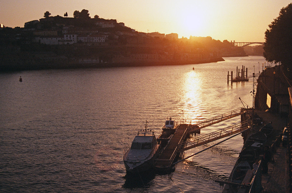 a boat docked in a body of water with a sunset.