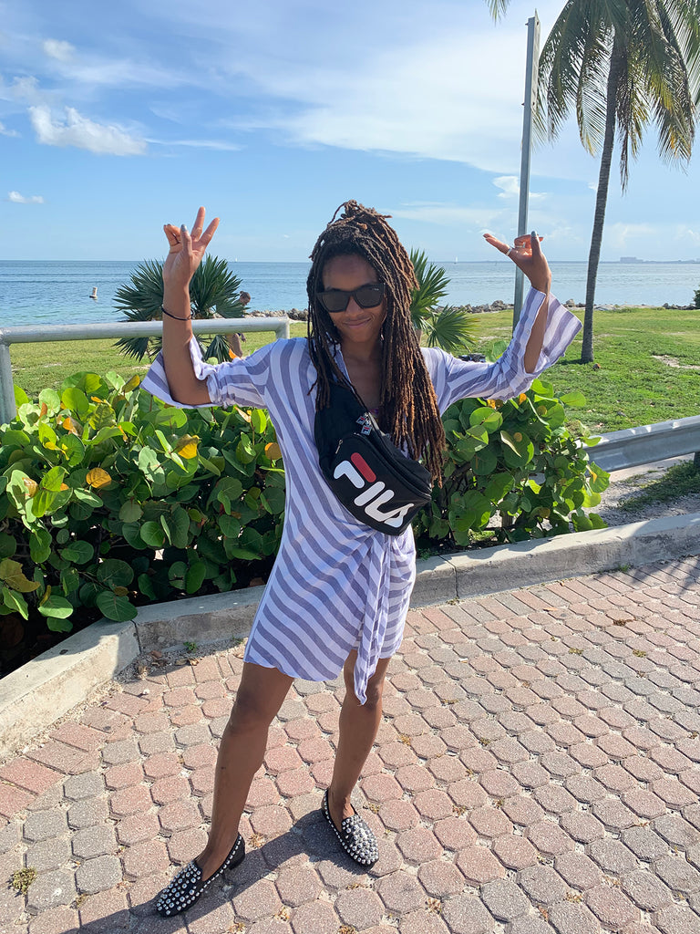 person with arms up making peace and love gesture at the beach.