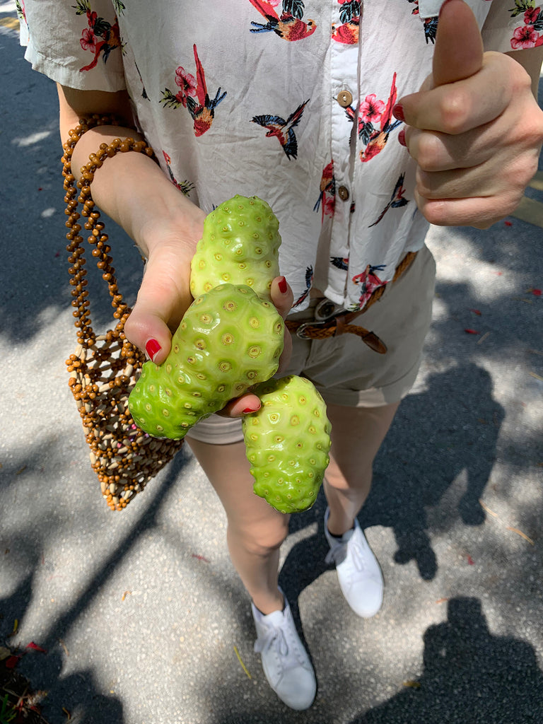 person holding green fruits.