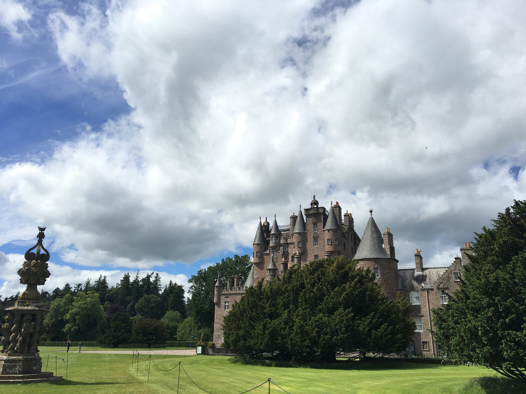 a castle in scotland with a statue in front of it.