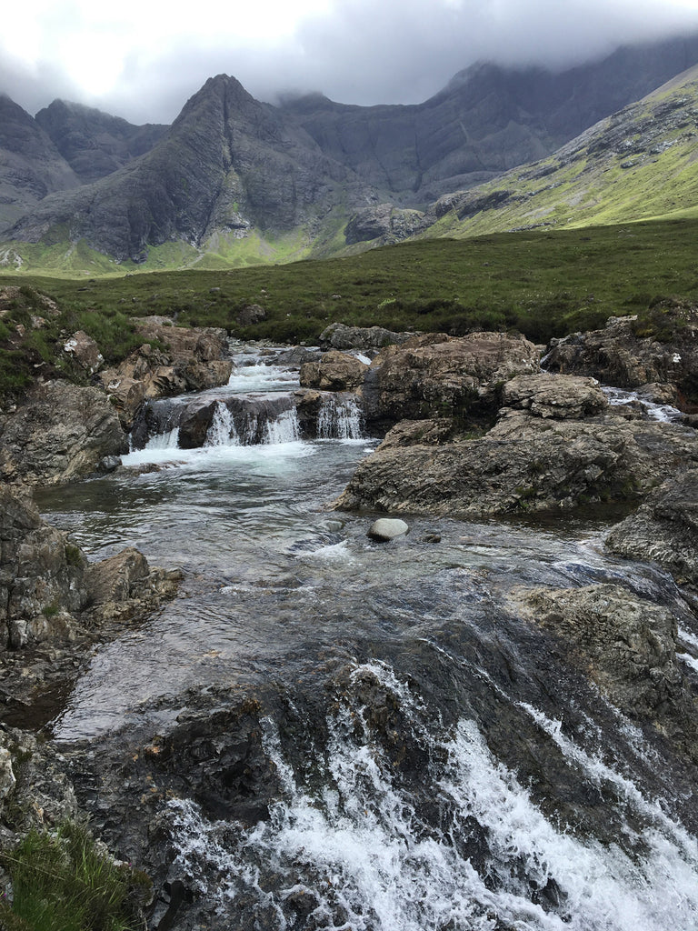 a stream running through a mountain in the scottish highlands.