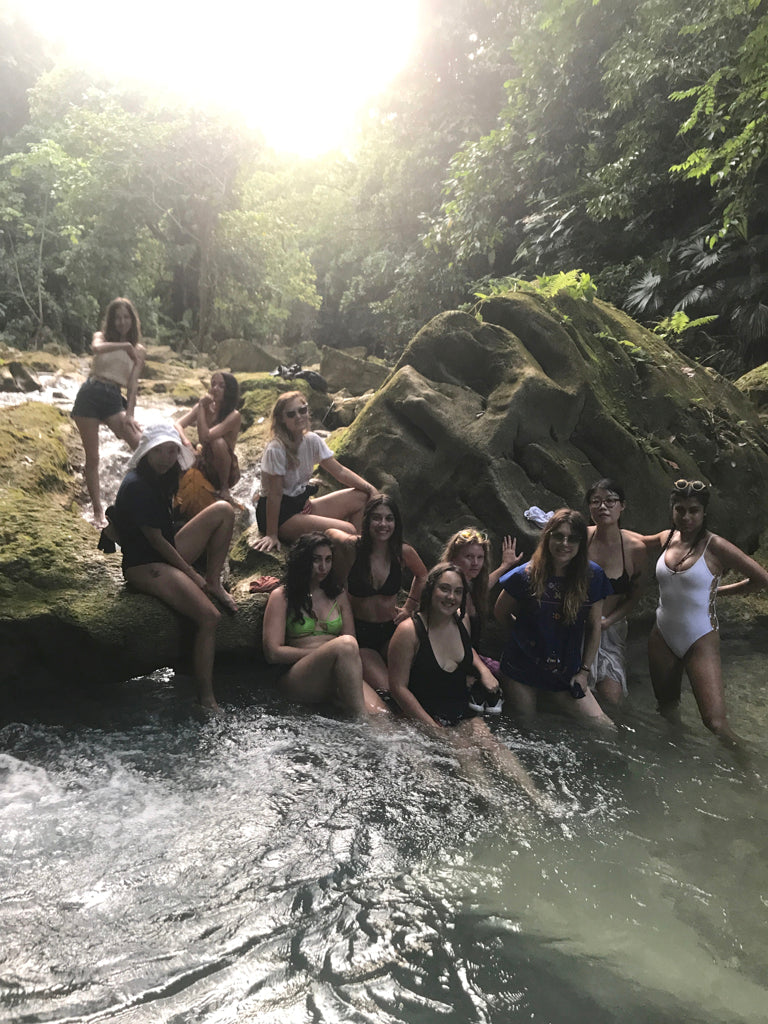 a group of people posing for a picture in a river.