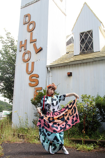 a person with colorful dress posing in front of a building.