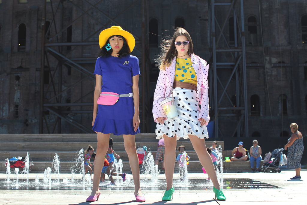 models standing posing in front of waterfall. 