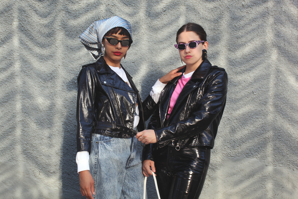 two models posing together in leather jackets.